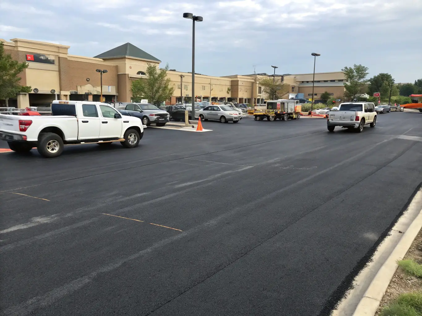 A freshly paved asphalt parking lot with clear markings and signage.